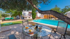 stół z jedzeniem pod drzewem obok basenu w obiekcie El Reposo Alhaurín de la Torre by Ruralidays w mieście Alhaurín de la Torre