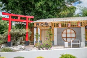 ein kleines Haus mit einem roten Tor und einem Gebäude in der Unterkunft heaven villa at pua in Ban Wang Khon