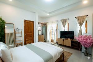 ein Schlafzimmer mit einem großen Bett und einem Fernseher in der Unterkunft heaven villa at pua in Ban Wang Khon