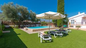 podwórze z krzesłami, parasolem i basenem w obiekcie El Reposo Alhaurín de la Torre by Ruralidays w mieście Alhaurín de la Torre