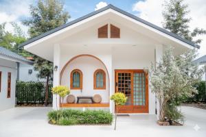 ein Haus mit einer weißen Fassade und einer braunen Tür in der Unterkunft heaven villa at pua in Ban Wang Khon