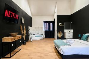 a bedroom with a bed and a bath tub at Suite Balnéo Privée Design Calme Proche Lille in Roubaix