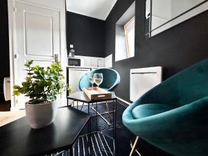a living room with two blue chairs and a table at Suite Balnéo Privée Design Calme Proche Lille in Roubaix