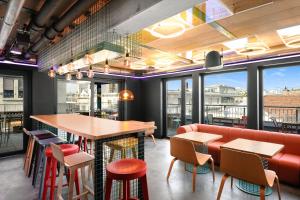 a restaurant with a bar and tables and chairs at JO&JOE Budapest in Budapest