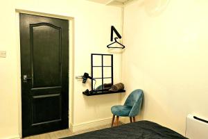 a bedroom with a black door and a blue chair at Flat - Sleeps 4 - WiFi in Bridgend