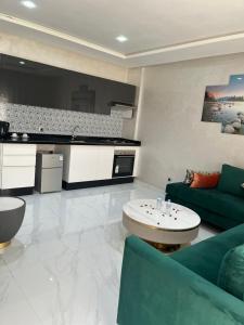 Una sala de estar con un sofá verde y una cocina. en Maarif elite Suites, en Casablanca 32 fotos más