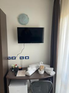 a room with a desk with a television on a wall at Hotel Ulisse in Marina Romea