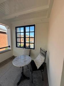 a room with a table and a chair and a window at Romantic Rouge Suite - With Round Bath in The Hague +4 photos