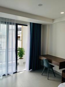 a room with a desk and a chair next to a window at Lumia Hotel in Ho Chi Minh City