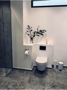 a bathroom with a toilet with a plant on the wall at Exclusive First Floor with Designer Touches in Kongens Lyngby