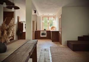 a living room with a wooden table and a kitchen at Stodoła pod lasem in Kuchary Żydowskie