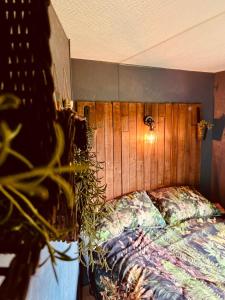 a bed with a wooden headboard in a bedroom at A static haven in Caernarfon