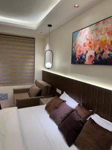 a bedroom with a bed and a painting on the wall at Easy Stayz - Premium stays in Greater Noida in Greater Noida +7 photos