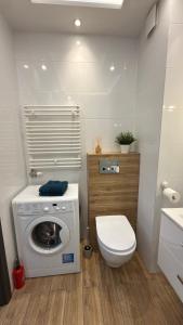 a bathroom with a washing machine and a toilet at 2 Tyskie Apartamenty z ogródkiem in Tychy +19 photos