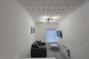 a living room with a couch and a table at Flat - Sleeps 4 - WiFi in Bridgend