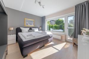 a bedroom with a bed and a large window at 6 East Ferienhaus in Niendorf