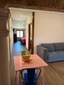 a living room with a pink table and a couch at Casa da Saboaria in Almeida +5 photos
