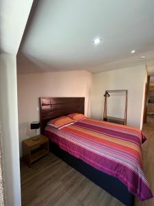 a bedroom with a bed with a colorful blanket at Casa da Saboaria in Almeida