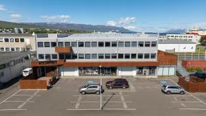 a large white building with cars parked in a parking lot at LL Properties - TB24 The Signature Loft in Akureyri