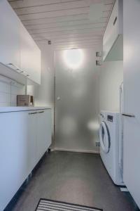 a laundry room with a washer and dryer at LakeVillas B4 - sis 4 kpl hissilippuja in Ukkohalla