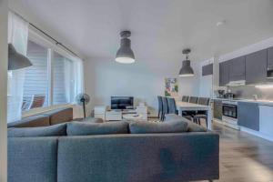 a living room with a couch and a kitchen at LakeVillas B4 - sis 4 kpl hissilippuja in Ukkohalla +10 photos