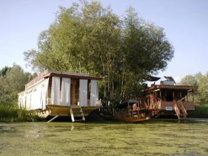 Dos casas están sentadas en el agua en un campo. en Houseboat Parimahal Deluxe, en Srinagar 35 fotos más