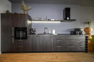 a kitchen with wooden cabinets and a sink and a microwave at LL Properties - TB24 The Signature Loft in Akureyri