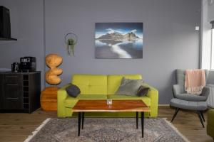 a living room with a yellow couch and a coffee table at LL Properties - TB24 The Signature Loft in Akureyri