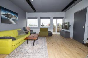 a living room with a yellow couch and a table at LL Properties - TB24 The Signature Loft in Akureyri