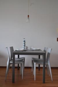 a dining room table with four chairs and a table and aermott at OTB Italia 1 - Luminoso appartamento tra Venezia e Treviso con Terrazza e Posto auto Coperto in Preganziol