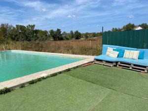 a blue couch sitting next to a swimming pool at Santuário SOS Animal in Casais da Carneiria