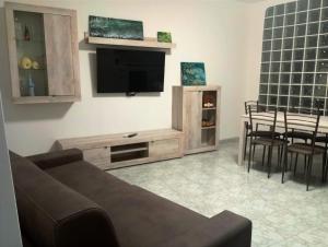 a living room with a couch and a flat screen tv at Almes' home in Bosisio Parini
