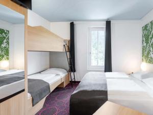 オッフェンブルクにあるB&B Hotel Offenburg-Cityのベッドが2つと窓があるホテルの部屋