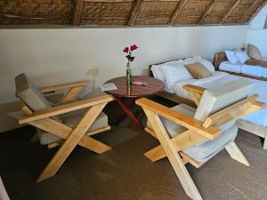 a room with a bed and a table and chairs at Bugoma Palms Resort Beach and Hotel in Namama Island