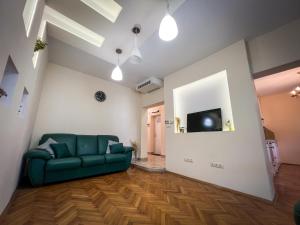 ヴァルナ・シティにあるThe Trinity Residenceの緑のソファとテレビのあるリビングルーム