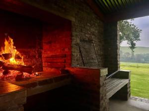 a fireplace with a bench in front of it at Treeferns Trout Lodge in Dullstroom