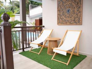 two chairs and a table on a balcony at Ocean Cove in Anse aux Pins