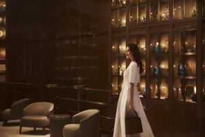 een vrouw in een witte jurk die door een kamer loopt bij The St. Regis Istanbul in Istanbul