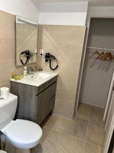a bathroom with a white toilet and a sink at Hôtel Comme chez soi in Jas +40 photos