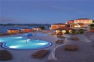 a swimming pool with lounge chairs and a resort at Skiper Apartments & Golf Resort in Savudrija