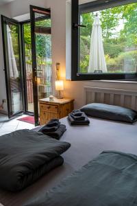 two beds in a room with a large window at Studio mit Terrasse bei Frankfurt in Bad Vilbel