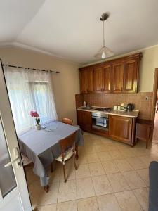 a kitchen with a table with a vase of flowers on it at Apartment LANA on the seashore in Kamenarovići