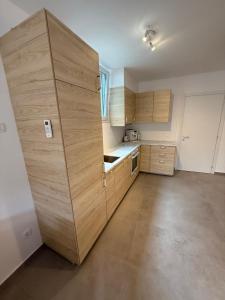 a kitchen with wooden cabinets and a large wooden wall at Ambijent in Sesvete +13 photos