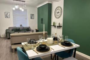Un comedor con una mesa con copas de vino. en House - Sleeps 5 - Garden - Parking, en Bridgend