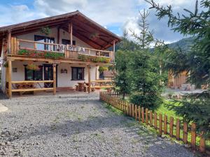 een huis met een hek ervoor bij Cabana Mareea -Lunca Bradului in Lunca Bradului