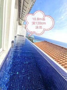 Una piscina en un hotel con un cartel que dice océano. en Ample Villa 小希臘民宿, en Ruifang