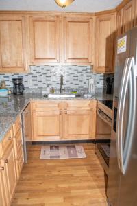 a kitchen with wooden cabinets and a stainless steel refrigerator at Winterplace Condos - Ski in Ski out E104 in Ghent