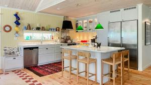 eine Küche mit einer großen weißen Insel mit Barhockern in der Unterkunft Stone House With Sea View In Katthammarsvik in Katthammarsvik
