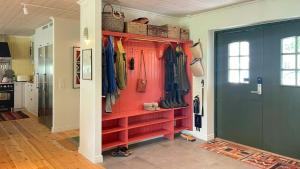 ein begehbarer Kleiderschrank mit roten Regalen und Kleidung in der Unterkunft Stone House With Sea View In Katthammarsvik in Katthammarsvik + 31 Fotos
