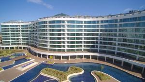 a large building with a pool in front of it at Cozy Stay Free Pool Spa & Gym Close to Beach&Mall in Lara